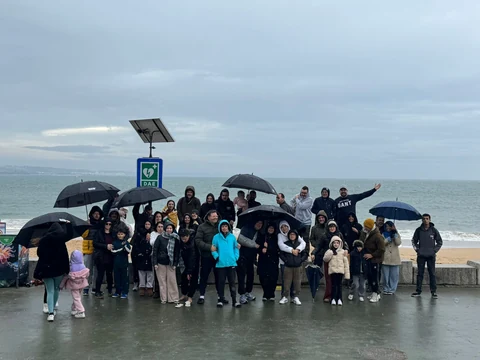 Grupo reunido numa praia junto ao mar