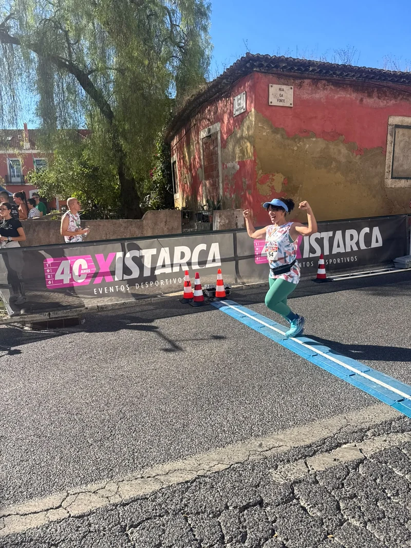 Participante a saltar sobre a linha azul da chegada da corrida