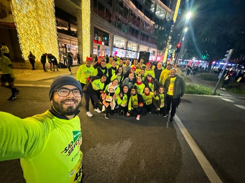 Grupo com camisolas amarelas reunido à noite numa avenida iluminada