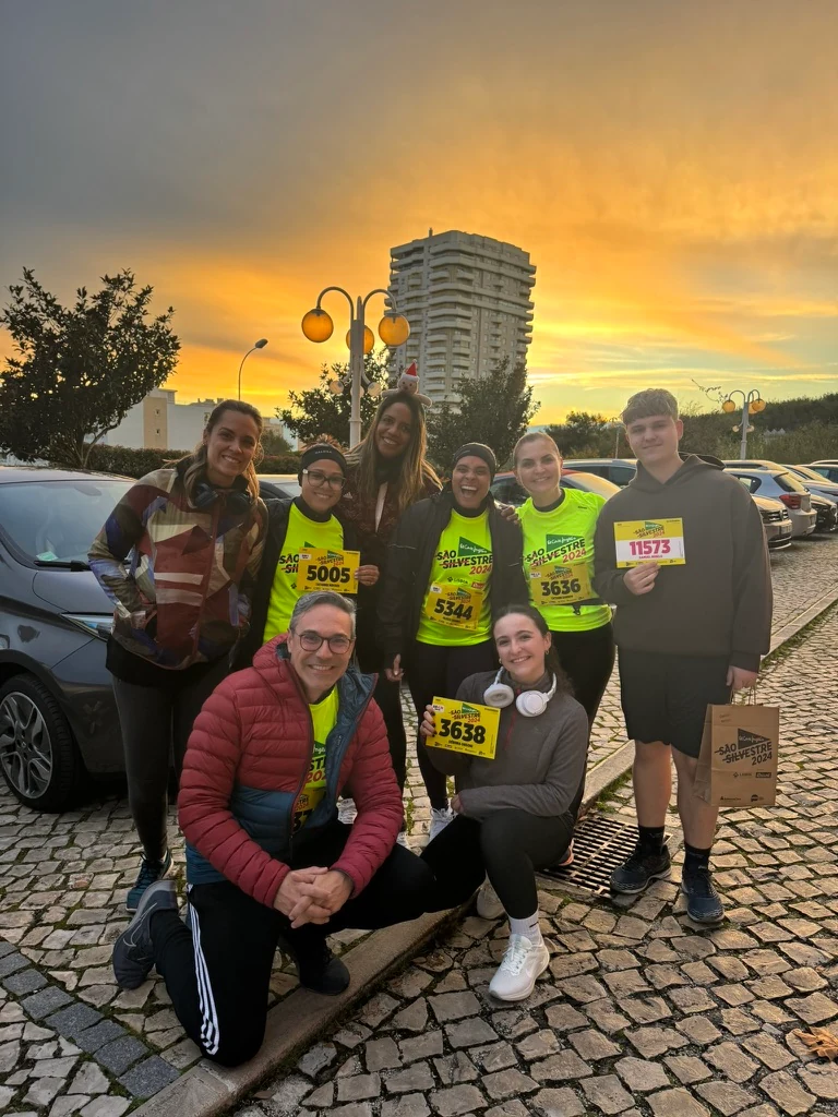 Grupo com dorsais de corrida reunido ao pôr do sol