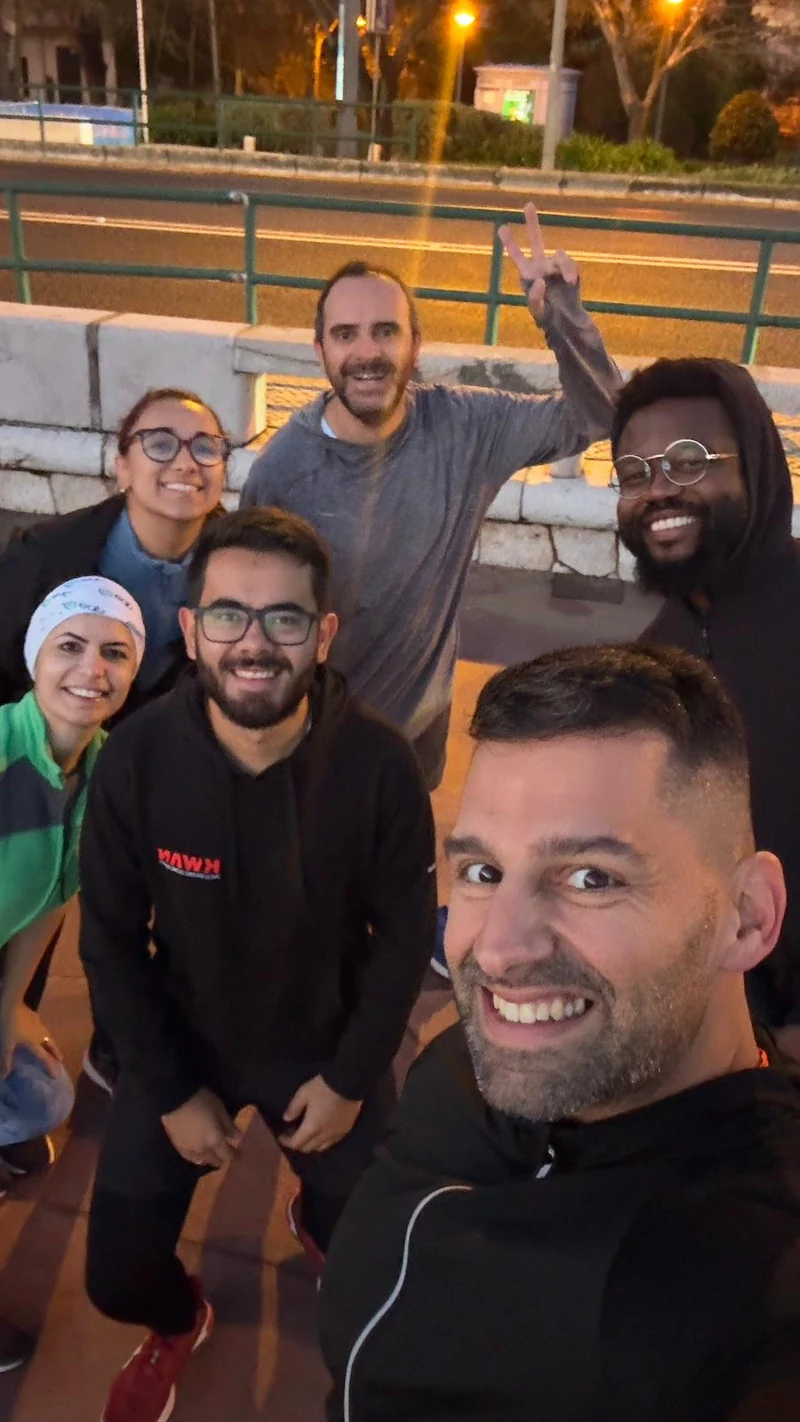 Seis pessoas a sorrir numa fotografia em conjunto à noite
