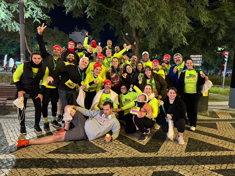 Grupo reunido à noite, com camisolas amarelas e medalhas