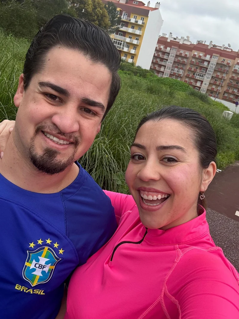 Duas pessoas com roupa desportiva a sorrir junto a uma zona verde