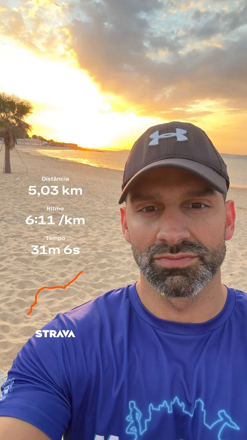 Pessoa com boné na praia ao pôr do sol, numa fotografia com um registo de corrida