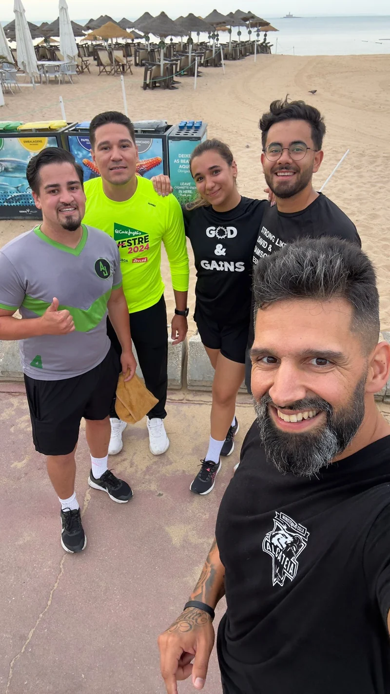 Cinco pessoas com roupa de treino reunidas junto à praia
