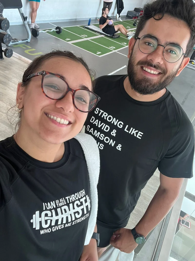 Duas pessoas com roupa de treino num ginásio com equipamento de força